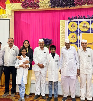 Guests with students Jainam and Jivika on stage during a formal school function