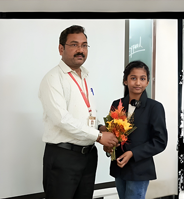 Student Jivika receiving appreciation during a school ceremony