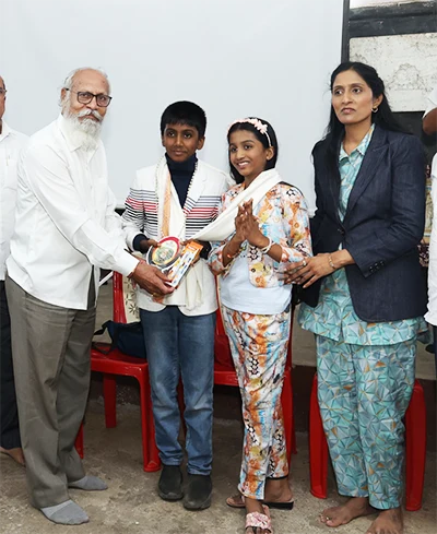 Jainam and Jivika receiving an award at an educational event