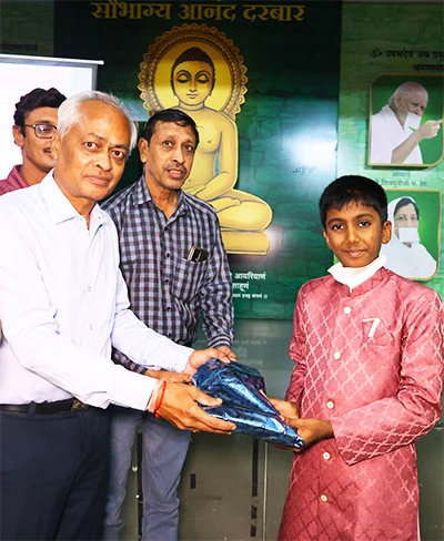 Jainam receiving recognition at an event