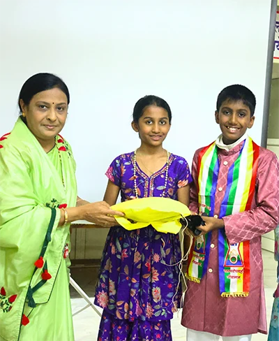Jainam and Jivika receiving recognition at an event